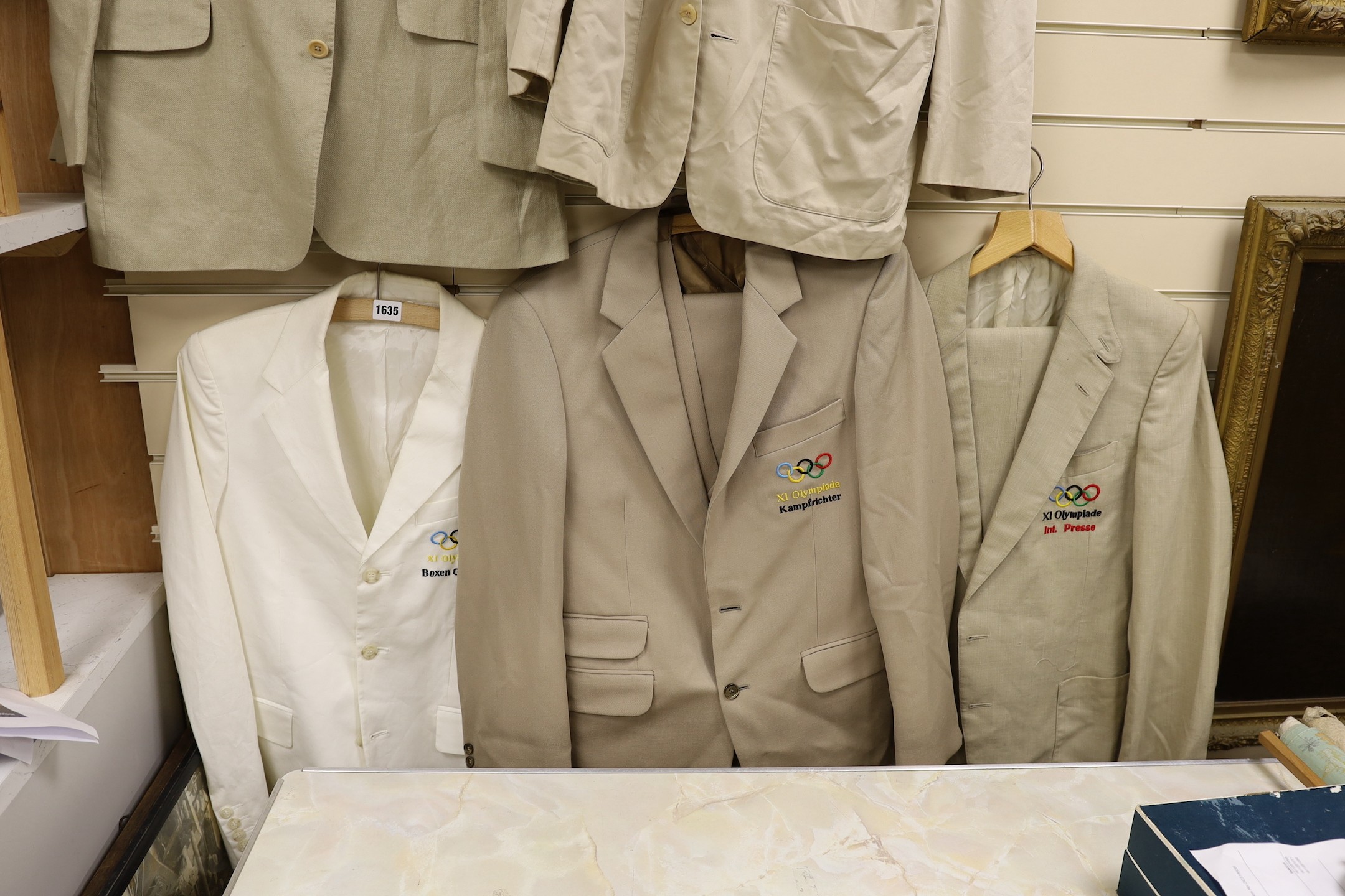 Four gentlemen’s cream suits and similar jacket, each bearing Berlin Olympics insignia